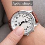 Close-up of a hand adjusting a silver analog wristwatch with a brown leather strap on the wrist